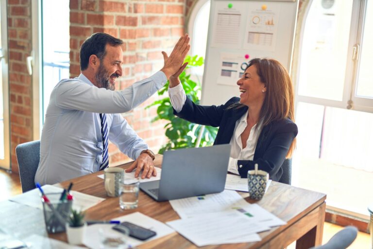 New hire being welcomed by a colleague at an office desk